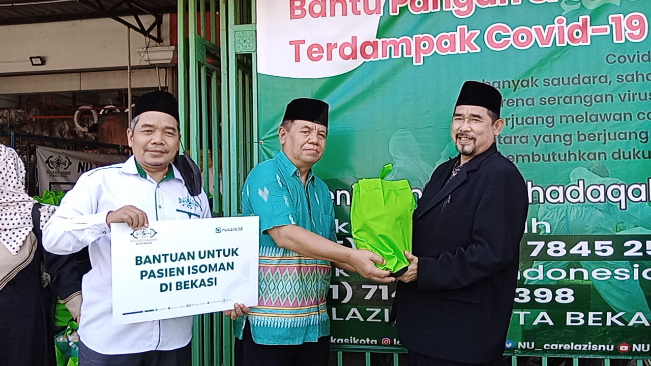 Ketua PCNU KH.Madinah Lc didampingi Ketua LazisNU Abd Muiz simbolis distribusikan paket sembako
