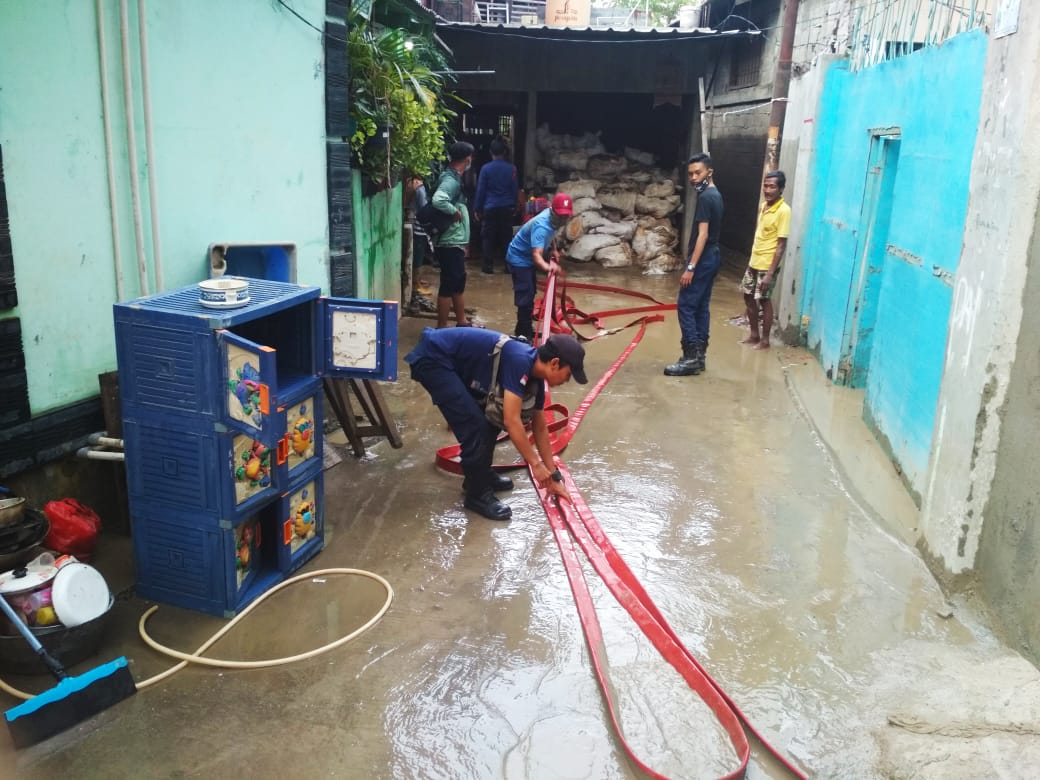 Petugas membersihkan lumpur korban banjir di Telukpucung Bekasi