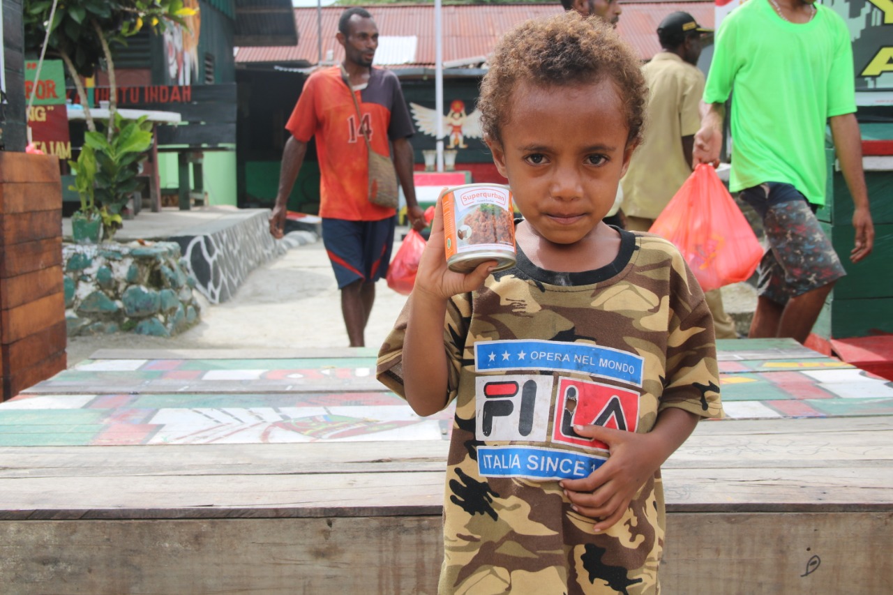 Seorang anak dari Papua memegang Superqurban adri Rumah Zakat