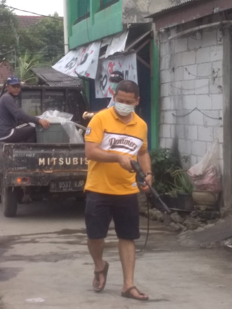 Daryanto sedang melakukan penyemprotan cairan disinfektan