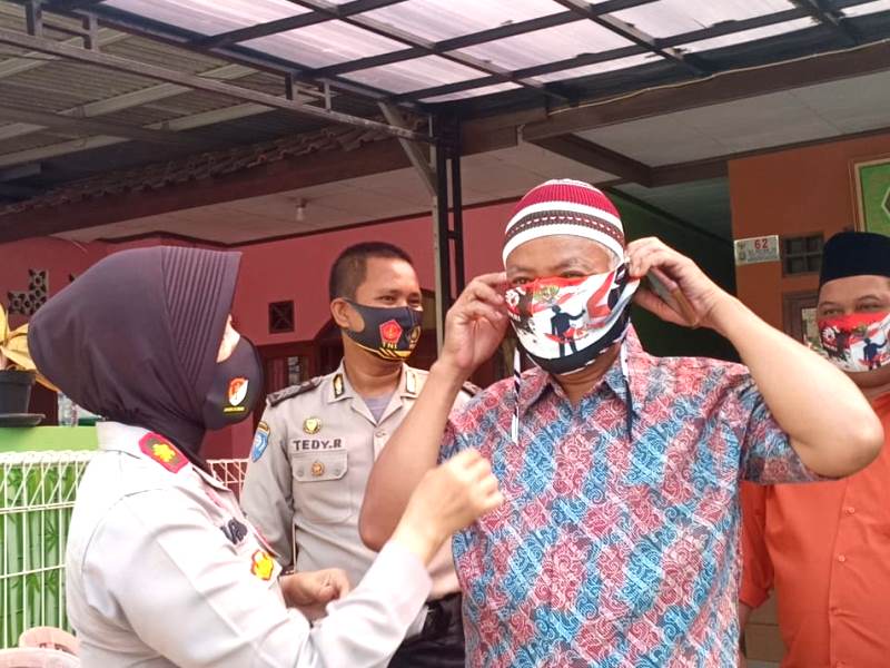 Kapolsek Bekasi Kota Kompol Armayni tengah membantu warga menggunakan masker