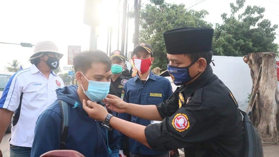 Ketua Katar Setu Leo Acep Juandi tengah memasang masker terhadap pengendara