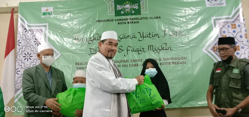 Ketua PCNU Kota Bekasi Kiai H.Madinah secara simbolis memberikan paket sembako