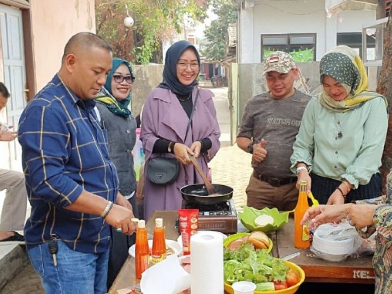 Lurah Cikiwul, Warsim Suryana (ketiga dari kanan) menyaksikan pembuatan burger