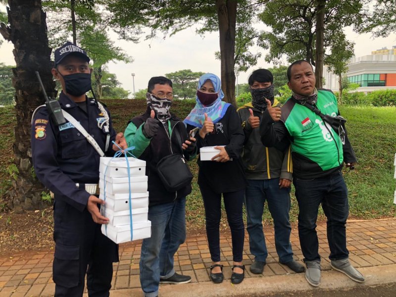 Wali murid SMPN 1 Kota Bekasi membagikan nasi box makan siang ke ojek online