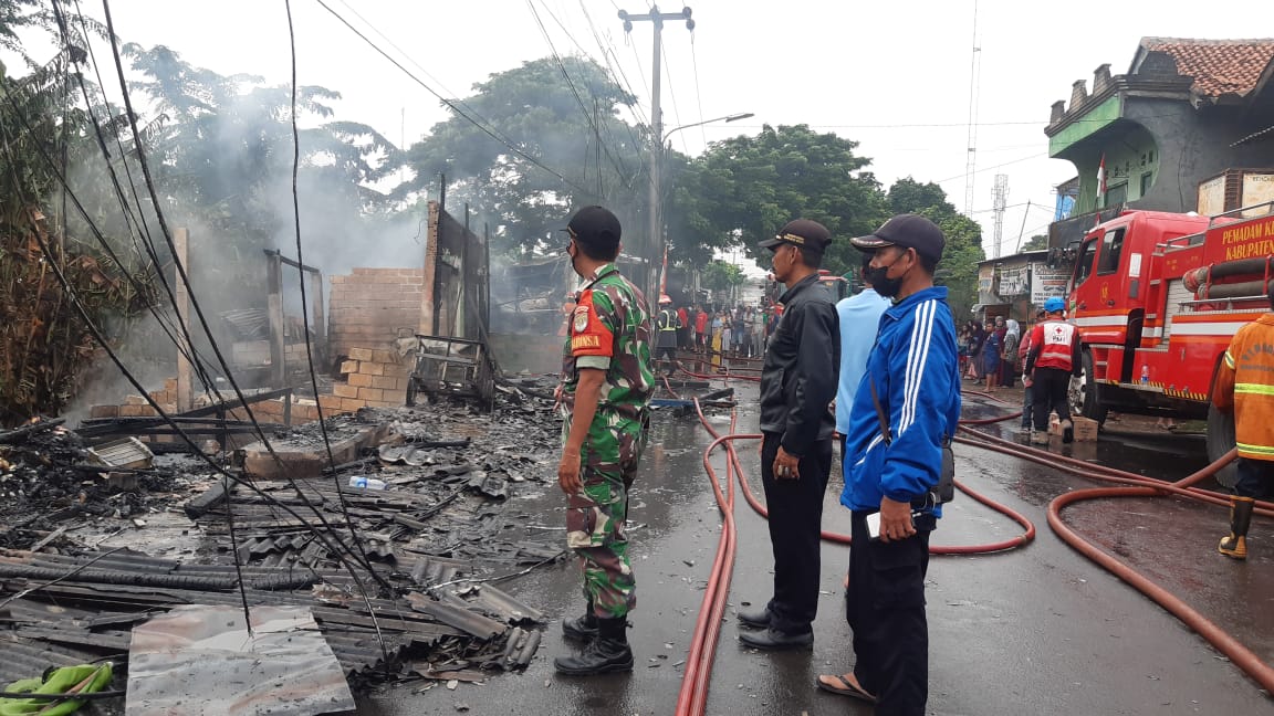 petugas melakukan pemadaman api di kios yang terbakar di Karang Satria Bekasi